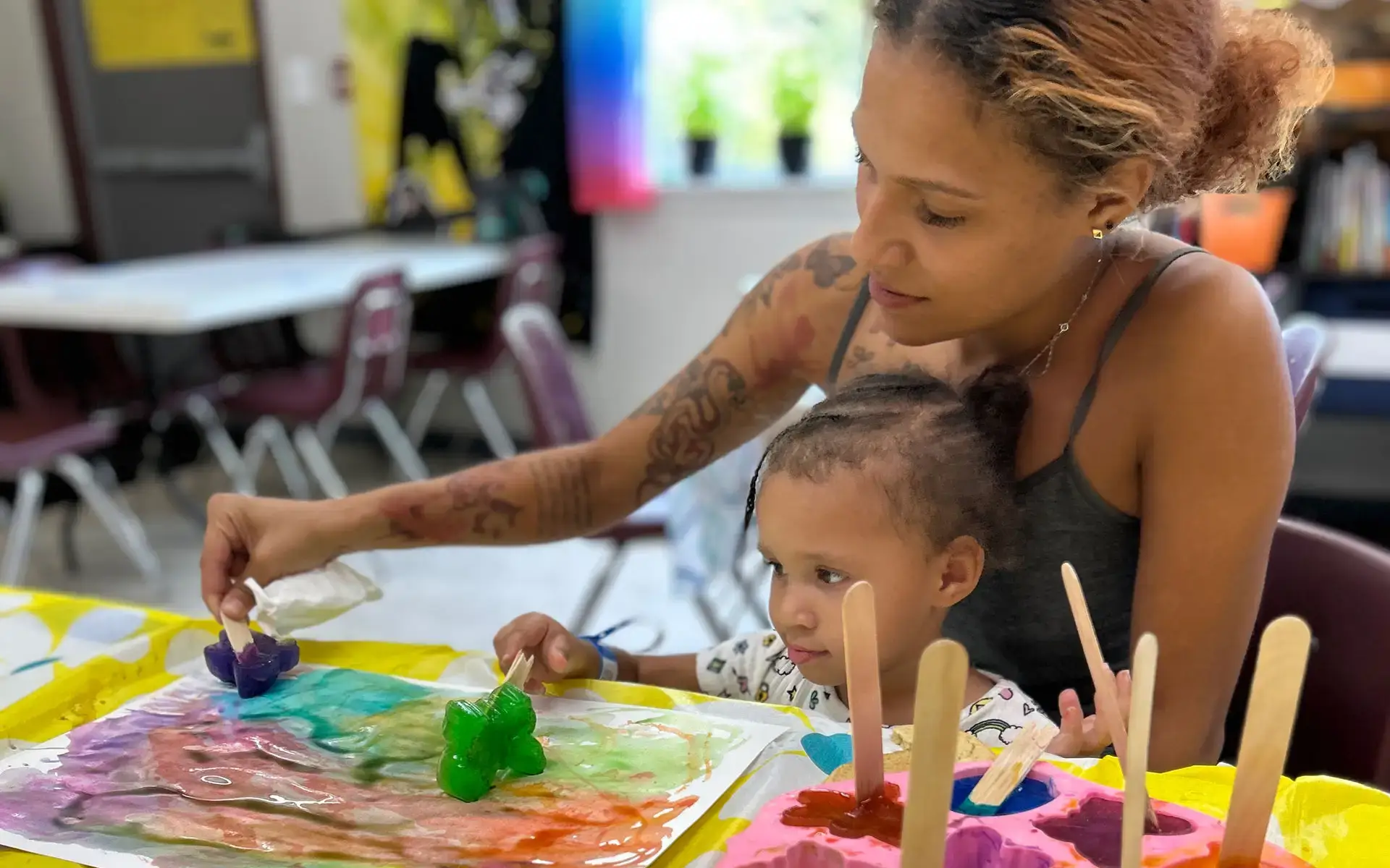 A mom and her two daughters in a community center at a Phoenix Family property