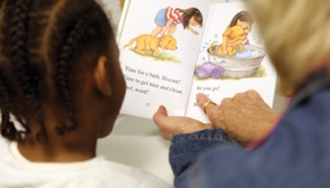 A volunteer reading coach working one-on-one with a child