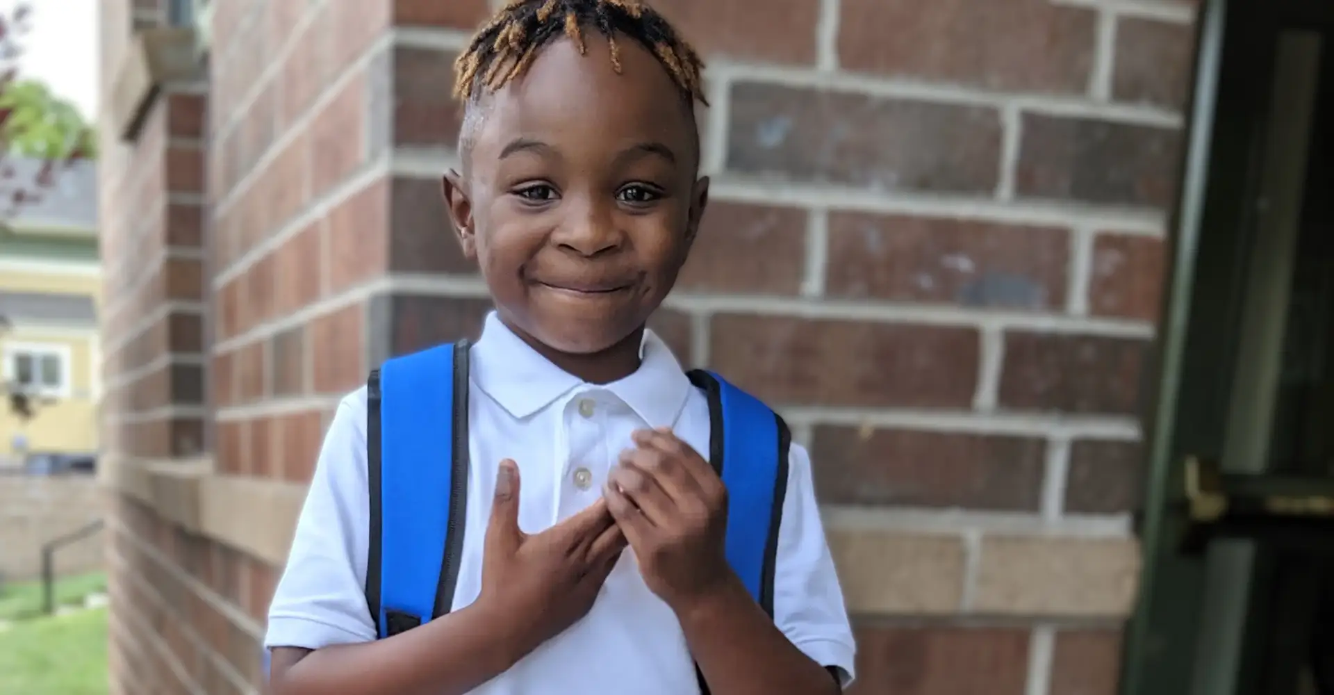 A Phoenix Family participant smiling outside with a backpack