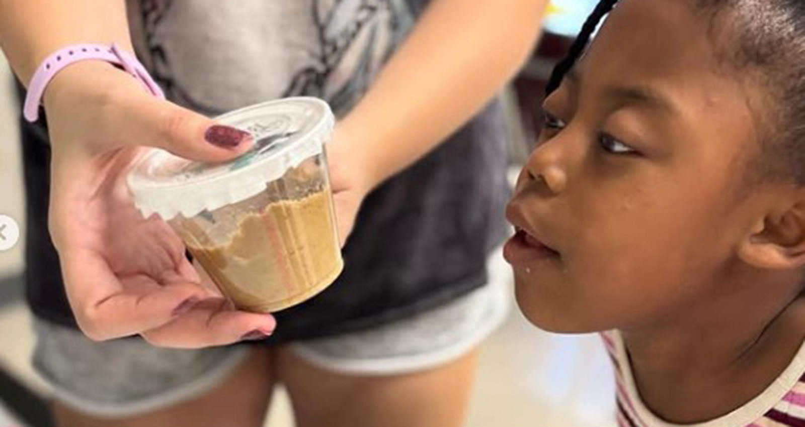 Child observing a science activity with a volunteer at a Phoenix Family learning program