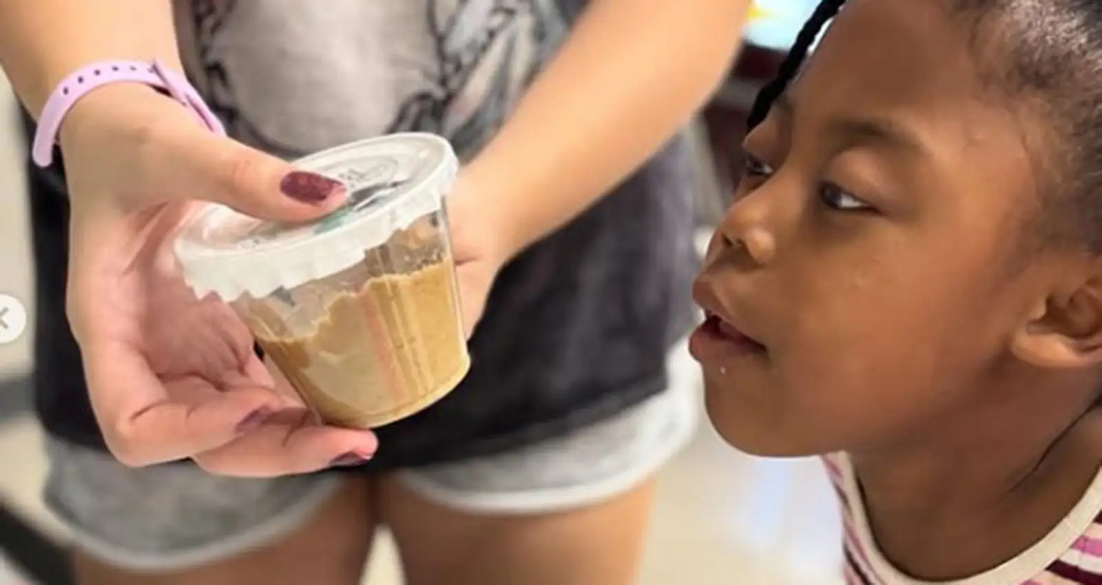Child observing a science activity with a volunteer at a Phoenix Family learning program