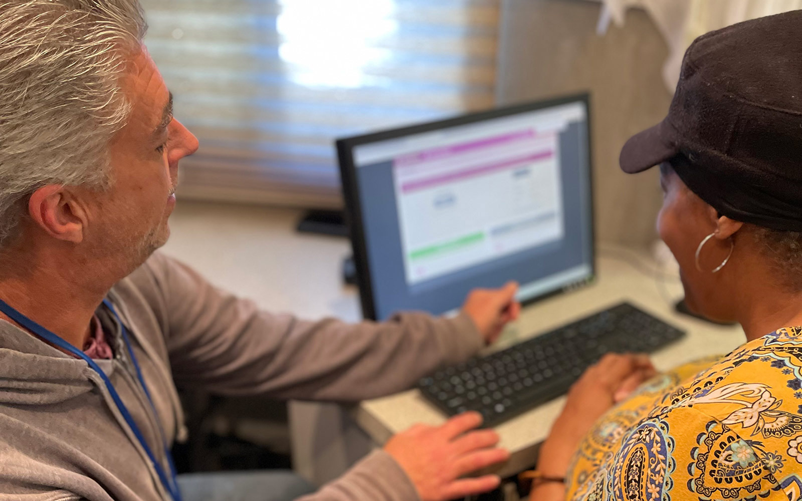 A volunteer helping a resident learn how to use a computer